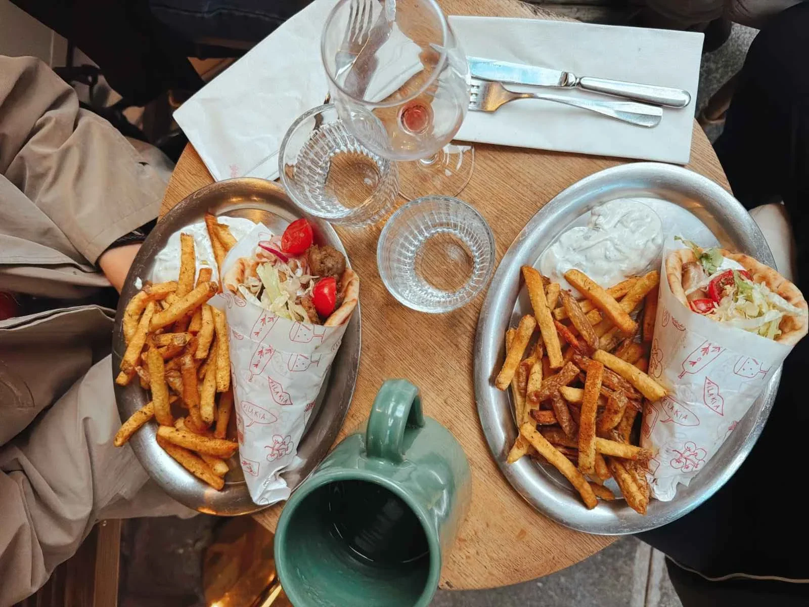 Delicious gyro wraps with fries on a wooden table, ready for lunch indoors.