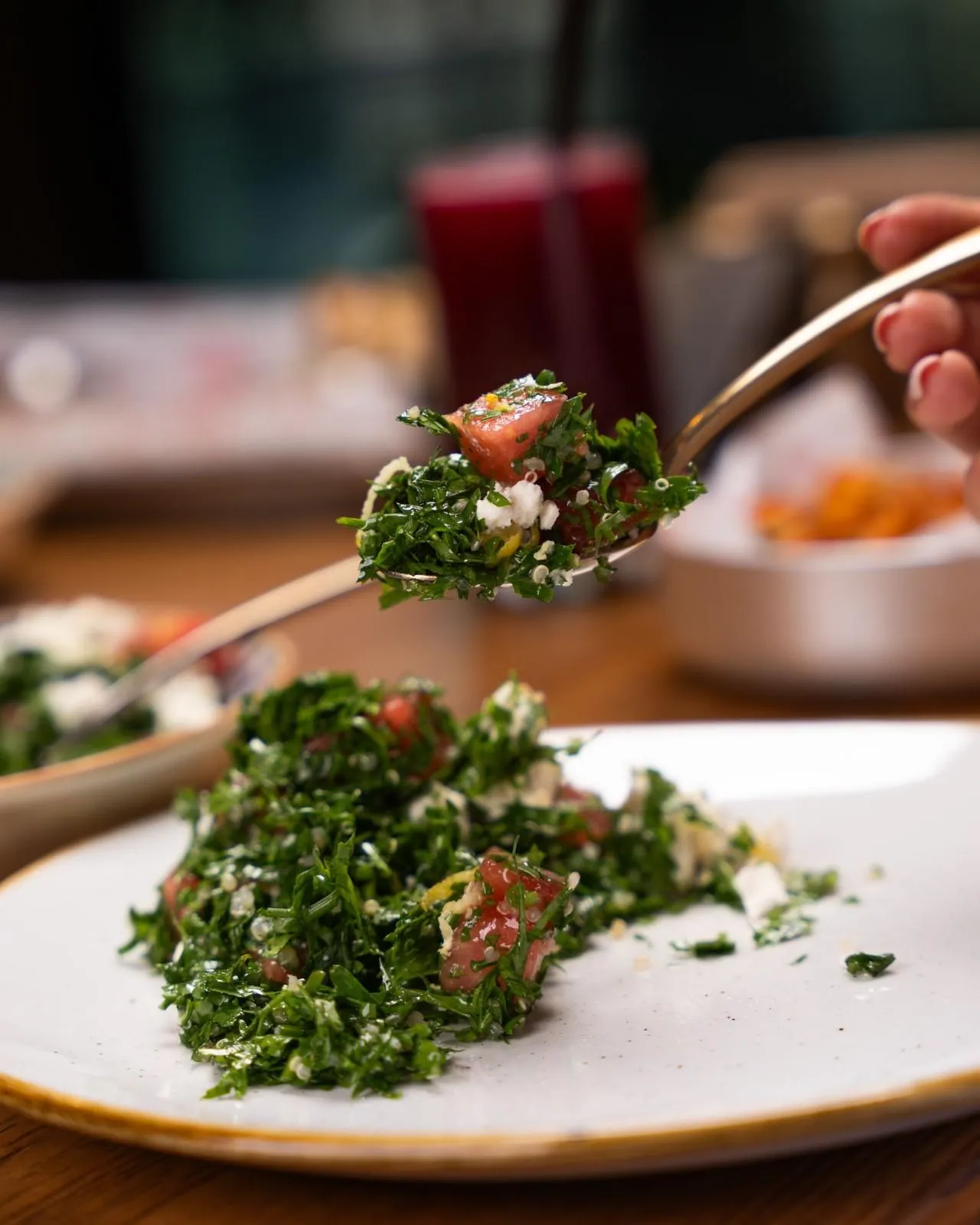 Delicious tabbouleh salad with tomatoes and greens on a fork, captured in a stylish setting.