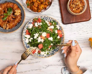 Vibrant tabbouleh salad with fresh ingredients, served with several mediterranean meals.